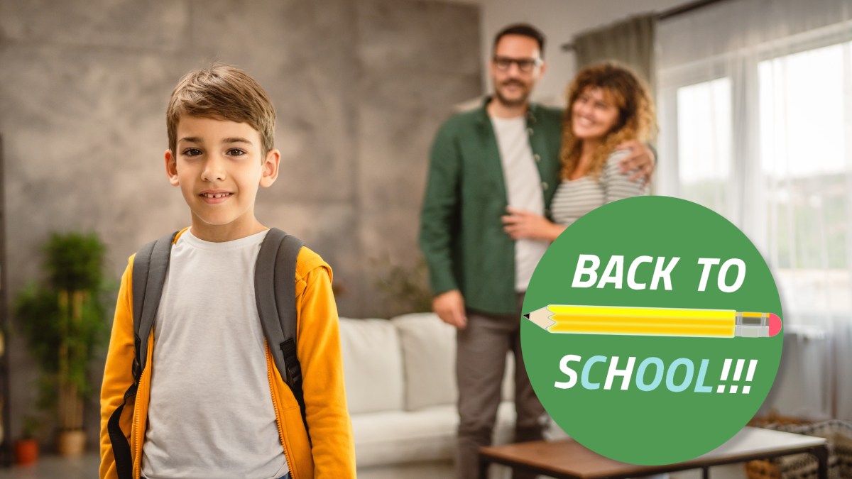 boy first day of school with parents in background - BACK TO SCHOOL