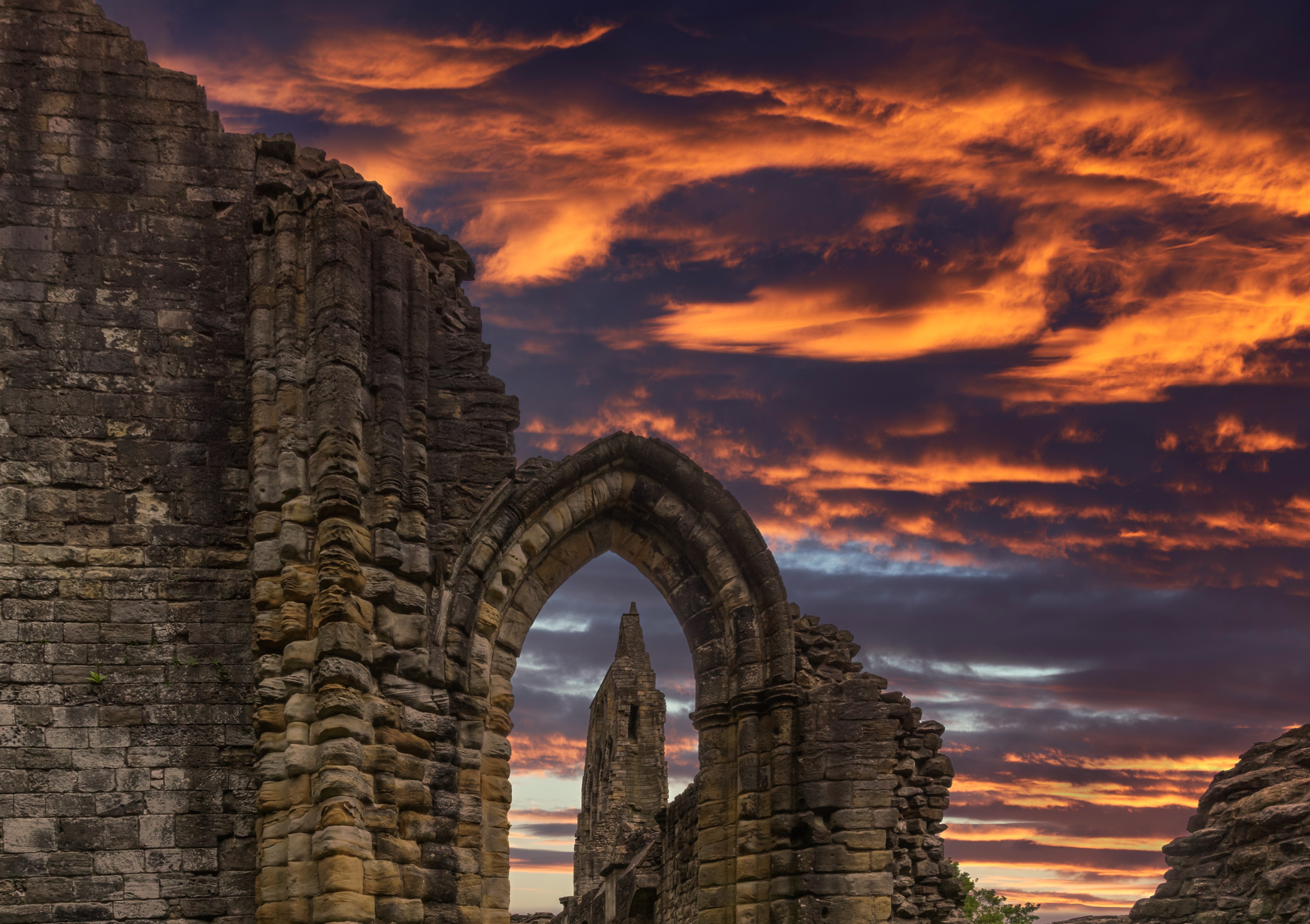 Looking-through-the-old-stone-entrance-to-The-Old-Transept-Ancient-Ruins-and-the-dramatic-sunset-sky-at-Kilwinning-Abbey-Scotland.jpg?resize=620