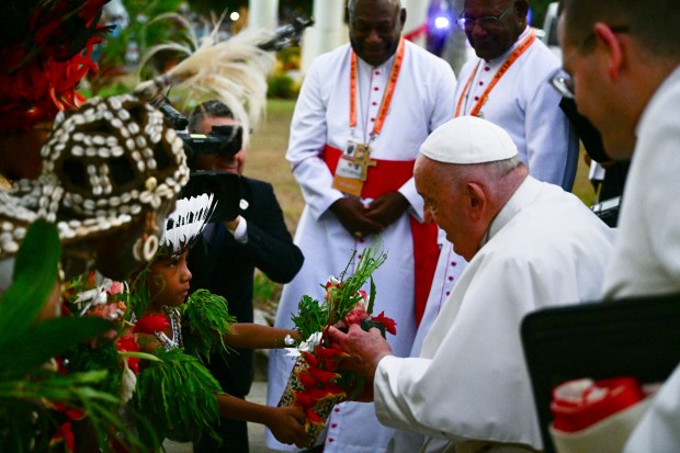 Pope Francis receives a gift as he arrives for a meeting with bishops and members of the clergy from Papua New Guinea and the Solomon Islands at the Shrine of Mary Help of Christians in Port Moresby on September 7, 2024.