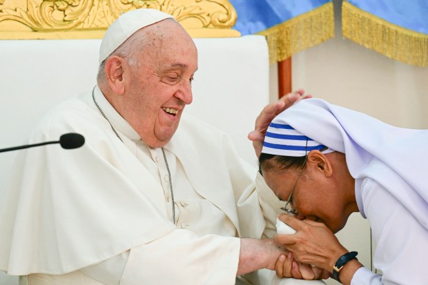 Pope Francis (L) is greeted as he visits the Irmas Alma School for Children with Disabilities in Dili on September 10, 2024.