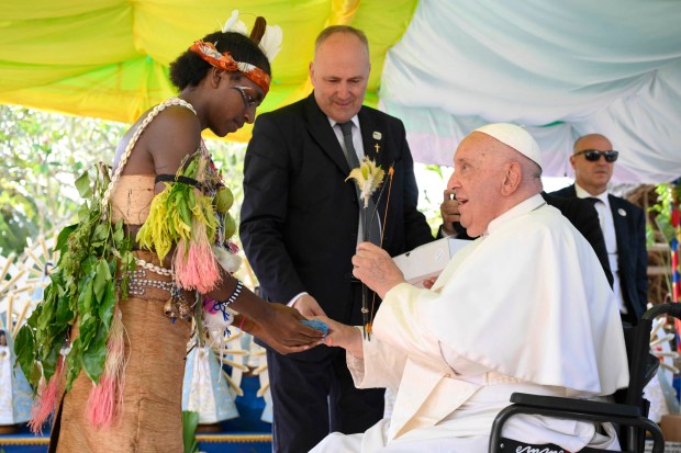 Pope Francis interacting with a youth during a meeting at the Holy Trinity Humanities School in Baro, Papua New Guinea.