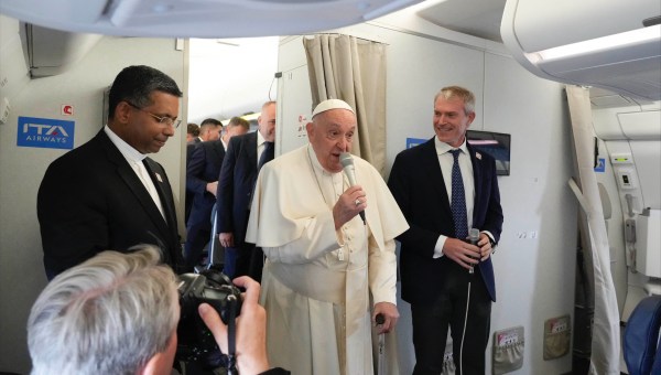 Pope Francis flanked by his spokeperson Matteo Bruni, speaks to journalists aboard his flight bound to Jakarta, Indonesia, where he will start a 12-day visit to Asia, on September 2, 2024.