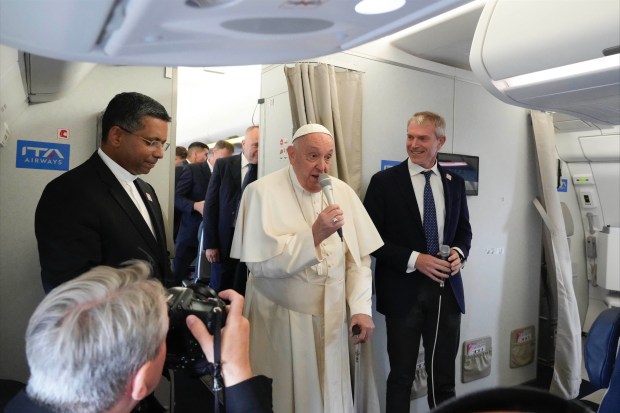 Pope Francis flanked by his spokeperson Matteo Bruni, speaks to journalists aboard his flight bound to Jakarta, Indonesia, where he will start a 12-day visit to Asia, on September 2, 2024.