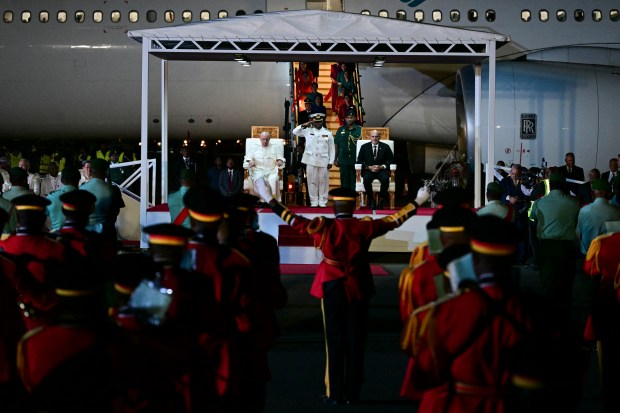 Pope Francis (L) takes part in a welcome ceremony with Papua New Guinea's Deputy Prime Minister John Rosso (R) upon arrival at the Port Moresby International airport on September 6, 2024.