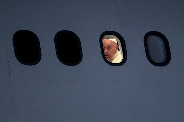 Pope Francis is seen through a window of the plane upon arrival at Port Moresby International airport on September 6, 2024.