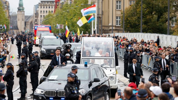 Pope Francis (C) waves to believers as he leaves the Cercle Cite after a meeting Luxembourg's Prime minister during a four-day apostolic journey in Luxembourg and Belgium, in Luxembourg city on September 26, 2024
