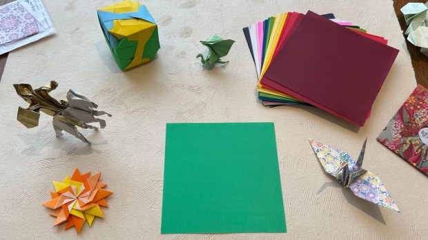 Desk with origami paper and figures on it