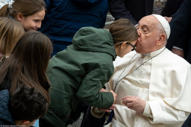Pope Francis kisses a young girl at the end of his weekly general audience in Paul VI Hall at the Vatican on January 15, 2025