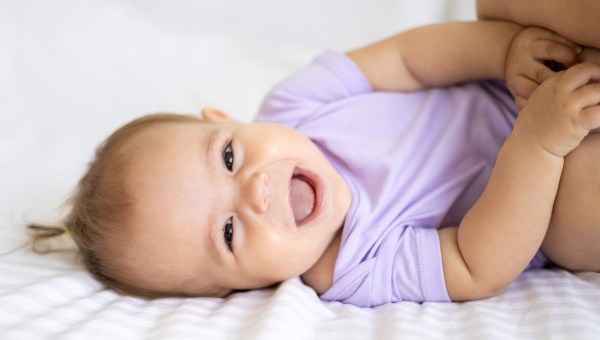 Smiling newborn girl in purple outfit