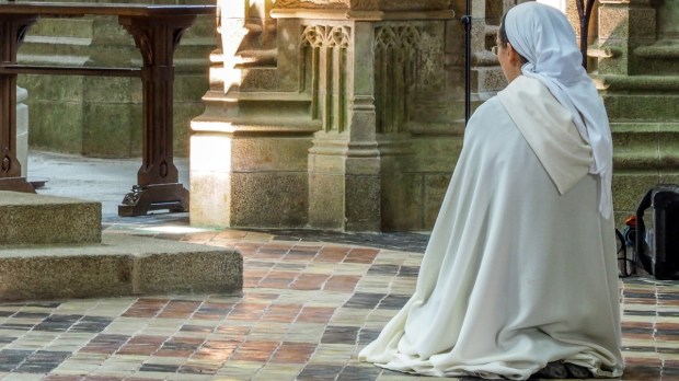 nun kneeling in prayer