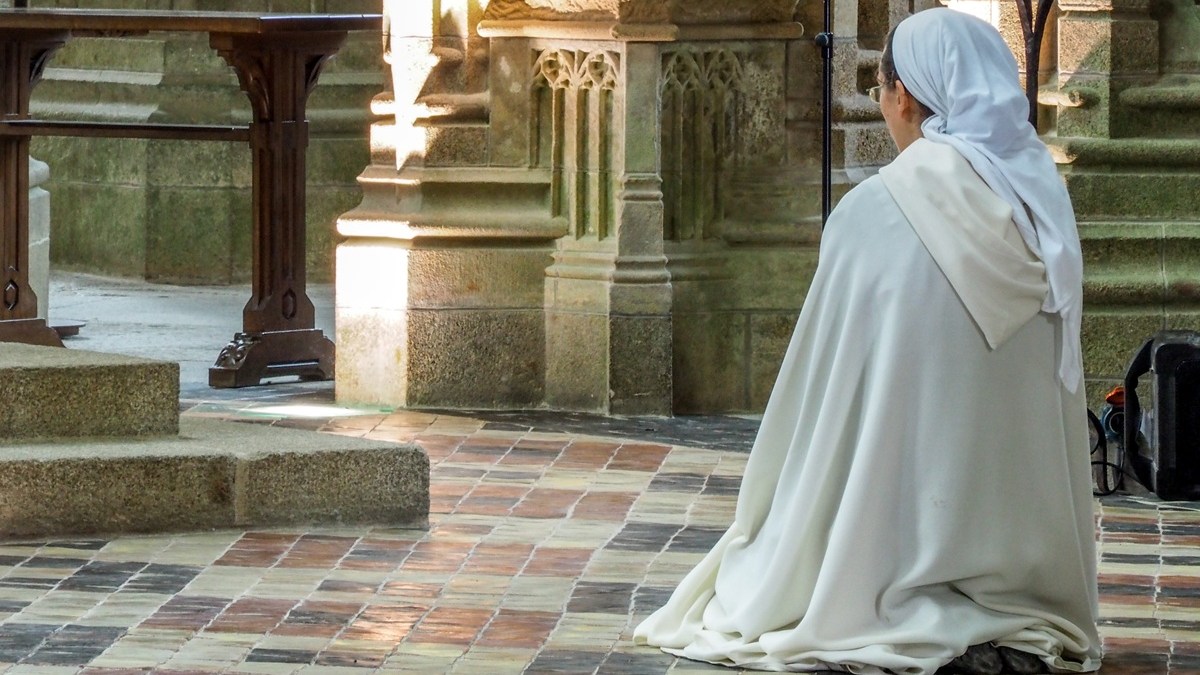 nun kneeling in prayer