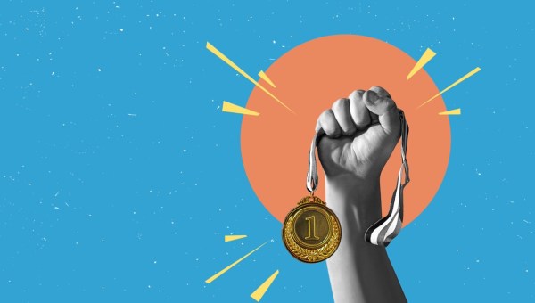 Dłoń trzymająca złoty medal