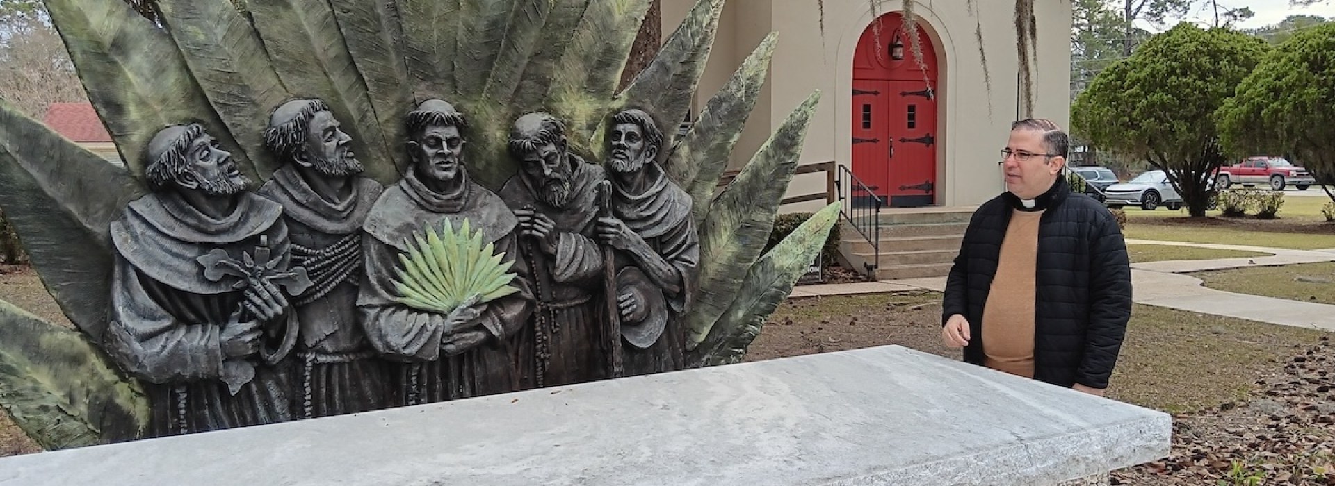 Fr. Pablo Migone in front of Georgia Martyrs sculpture