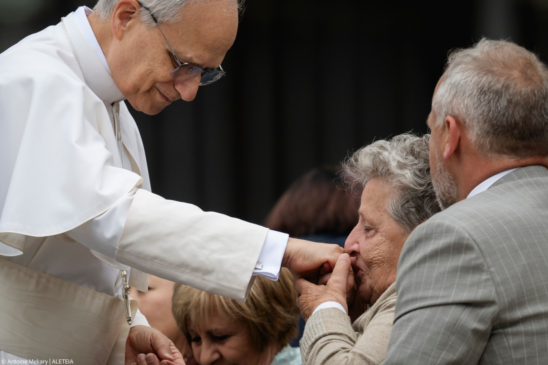 A woman kisses the hand Pope Leo XIV at the end of his first weekly general audience at St Peter's Square in The Vatican on May 21, 2025