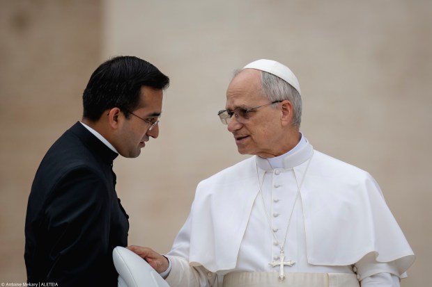 Pope Leo XIV speaks to his personal assistant Edgard Ivan Rimaycuna Inga at the end of his first weekly general audience at St Peter's Square in The Vatican on May 21, 2025.