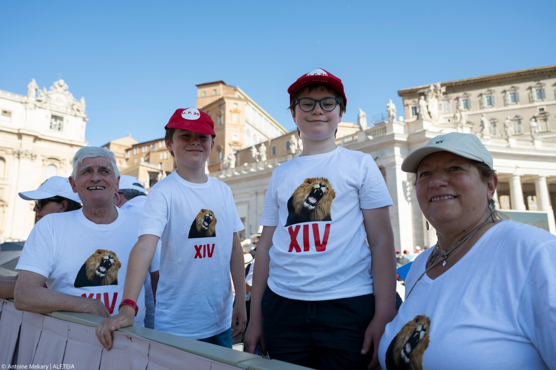 Faithful wear T-shirts featuring a lion and the inscription "XIV" as Pope Leo XIV celebrates the Mass for the Jubilee of families, children, grandparents, and the elderly in St. Peter's Square, Vatican City, on June 1, 2025.
