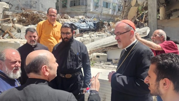 Cardinal Pizzaballa in Gaza with Fr. Romanelli (in the left foreground, pointing at the cardinal)