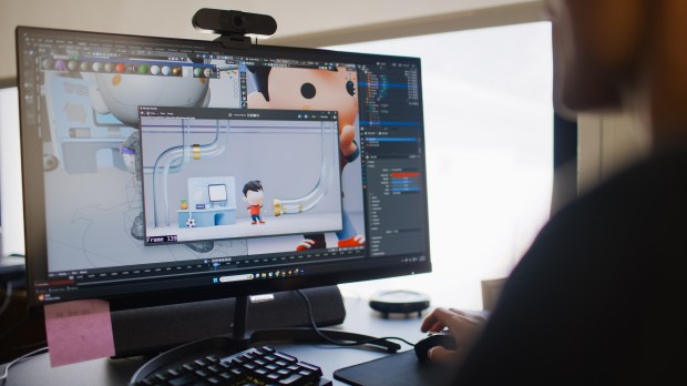 A person on a computer designing a tiny saint cartoon