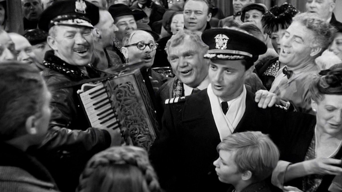 Ward Bond on accordion, Charles Halton (in round glasses), Thomas Mitchell, Todd Karns (in uniform), Frank Faylen, and Beulah Bondi.