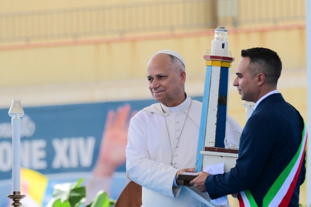 Pope Leo XIV (L) receives a sculpture of the lighthouse by Lampedusa mayor Filippo Mannino as he is welcomed upon arrival for a mass during a one day visit to Lampedusa island, south of Sicily, on July 4, 2026.