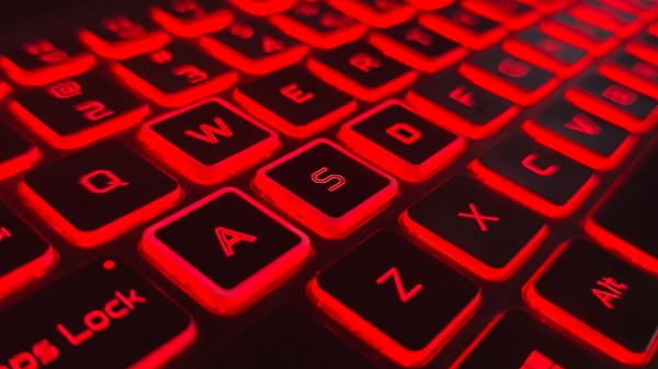 Primer plano de un teclado de portátil iluminado con una llamativa retroiluminación roja. La Imagen destaca las teclas, lo que indica una estética de juego o portátil de rendimiento.